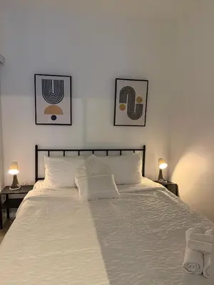 a bedroom with a white bed with two pictures on the wall at Luxury Condo Downtown Toronto in Toronto