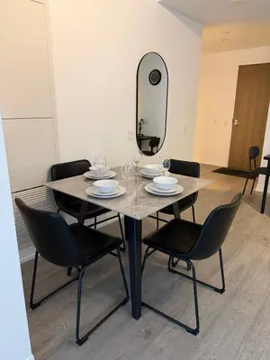 a dining room table with chairs and a mirror at Luxury Condo Downtown Toronto in Toronto
