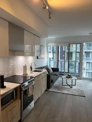 a kitchen and living room with a couch at Luxury Condo Downtown Toronto in Toronto
