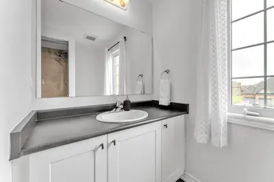 a white bathroom with a sink and a mirror at Spacious & New Prince Edward County Villa in Carrying Place