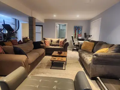a living room with couches and a table at Cozy 2- bedroom private basement! in Mississauga