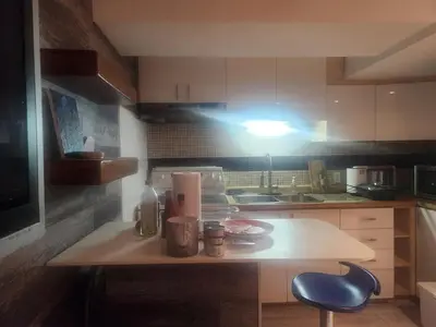 a kitchen with a table and a blue stool at Cozy 2- bedroom private basement! in Mississauga