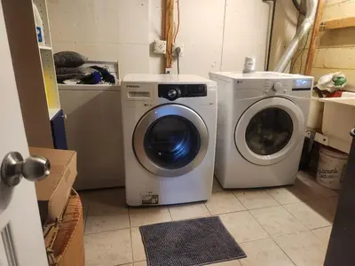 a dryer and a washing machine in a room at Cozy 2- bedroom private basement! in Mississauga