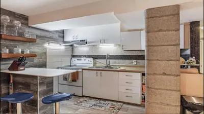 a kitchen with white cabinets and blue stools at Cozy 2- bedroom private basement! in Mississauga
