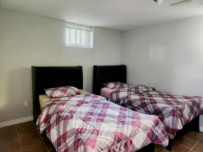 two beds sitting next to each other in a room at Cozy 2- bedroom private basement! in Mississauga