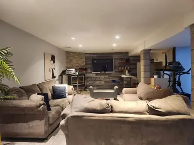 a living room with two couches and a television at Cozy 2- bedroom private basement! in Mississauga