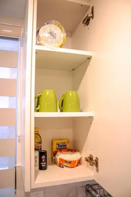 a kitchen pantry with green bowls and food on shelves at Oshawa Two Bedroom Private Suite in Oshawa