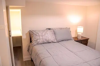 a bedroom with a bed with two lamps on a table at Oshawa Two Bedroom Private Suite in Oshawa