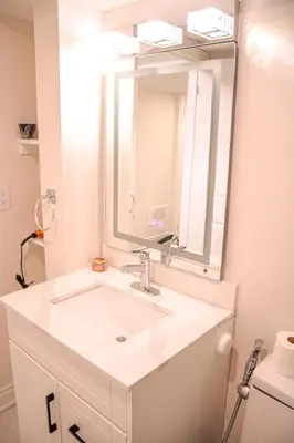 a bathroom with a white sink and a mirror at Oshawa Two Bedroom Private Suite in Oshawa