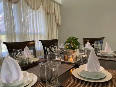 a dining room table with plates and napkins on it at Adorable 3 private rooms- main with free parking in Toronto