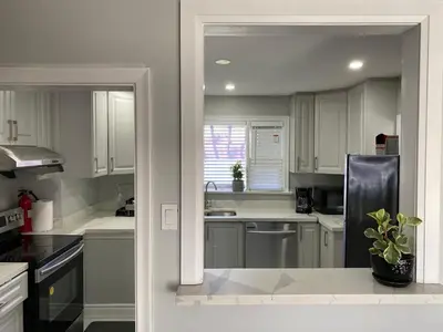 a kitchen with white cabinets and a black refrigerator at Adorable 3 private rooms- main with free parking in Toronto