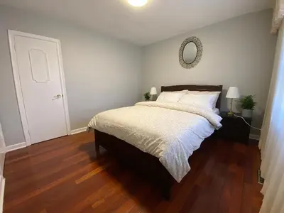 a bedroom with a bed and a mirror on the wall at Adorable 3 private rooms- main with free parking in Toronto