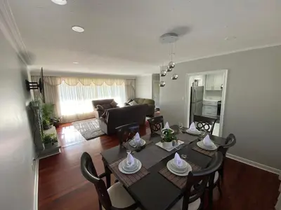 a living room with a table and chairs and a couch at Adorable 3 private rooms- main with free parking in Toronto