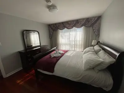 a bedroom with a large bed and a mirror at Adorable 3 private rooms- main with free parking in Toronto