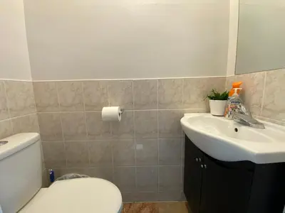 a bathroom with a white toilet and a sink at Adorable 3 private rooms- main with free parking in Toronto