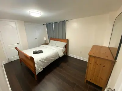 a small bedroom with a bed and a mirror at Adorable private 2 bedroom basement unit in Toronto