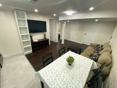 a living room with a table and a couch at Adorable private 2 bedroom basement unit in Toronto