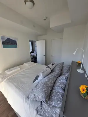 a bedroom with a large bed with pillows on it at Amazing one bedroom suite with panoramic downtown views in Toronto