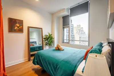 a bedroom with a bed and a large window at The Artist Loft Trendy 2BR Condo with Parking in Toronto