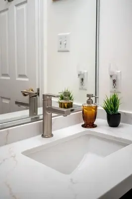 a bathroom counter with a sink and a mirror at The Artist Loft Trendy 2BR Condo with Parking in Toronto