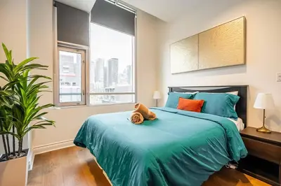 a bedroom with a bed with a teddy bear on it at The Artist Loft Trendy 2BR Condo with Parking in Toronto
