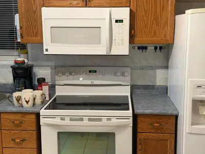 a kitchen with a white stove and a microwave at Cozy Private Basement Apartment in Fort Erie in Fort Erie