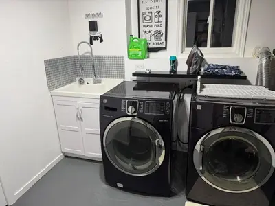 a kitchen with a washing machine and a sink at Cozy Private Basement Apartment in Fort Erie in Fort Erie