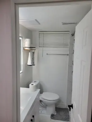 a white bathroom with a toilet and a sink at Stunning Partially Renovated Apartment in Toronto