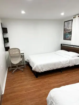 a bedroom with two beds and a desk and a chair at Stunning Partially Renovated Apartment in Toronto