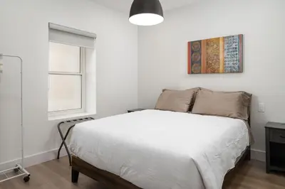a bedroom with a white bed and a window at Beam Loft in Beamsville