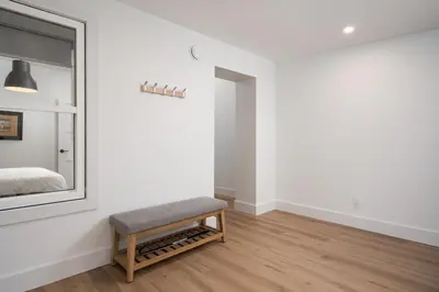 a bedroom with a bench and a mirror at Beam Loft in Beamsville