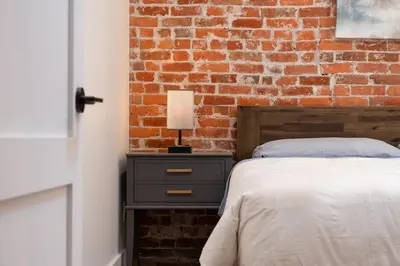 a bedroom with a brick wall and a bed at Beam Loft in Beamsville