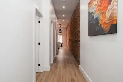 a hallway with white walls and a painting on the wall at Beam Loft in Beamsville