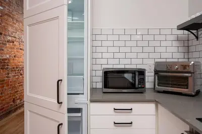 a kitchen with white cabinets and a microwave at Beam Loft in Beamsville