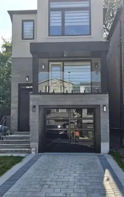 a building with a garage with a car in it at Brand New Private Unit with Parking, Steps to TTC, 15 Minutes to Downtown in Toronto