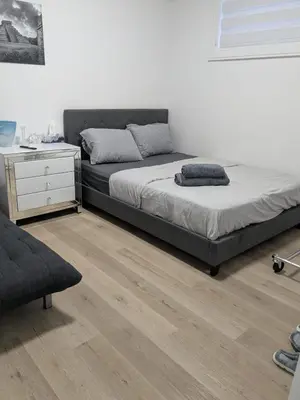 a bedroom with a large bed and a dresser at Brand New Private Unit with Parking, Steps to TTC, 15 Minutes to Downtown in Toronto