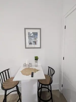 a white table with two chairs and a remote control on it at Brand New Private Unit with Parking, Steps to TTC, 15 Minutes to Downtown in Toronto