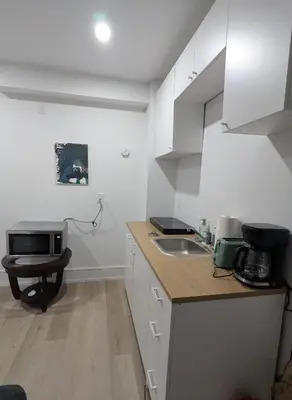 a kitchen with white cabinets and a sink and a microwave at Brand New Private Unit with Parking, Steps to TTC, 15 Minutes to Downtown in Toronto