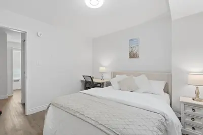 a white bedroom with a bed and a desk at Waterloo Paradise with Rec room, Workspace, Park and close to St Jacobs Market in Waterloo