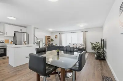 a kitchen and living room with a table and chairs at Waterloo Paradise with Rec room, Workspace, Park and close to St Jacobs Market in Waterloo