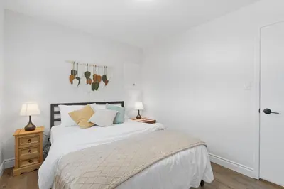 a white bedroom with a bed with white sheets and pillows at Waterloo Paradise with Rec room, Workspace, Park and close to St Jacobs Market in Waterloo