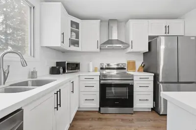 a kitchen with white cabinets and a stainless steel refrigerator at Waterloo Paradise with Rec room, Workspace, Park and close to St Jacobs Market in Waterloo