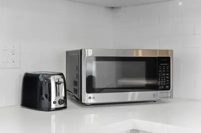 a microwave sitting on a counter next to a toaster at Waterloo Paradise with Rec room, Workspace, Park and close to St Jacobs Market in Waterloo