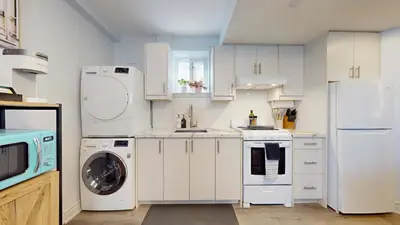 a kitchen with white appliances and a washer and dryer at New Bright 1BR Basement Suite in York in Toronto