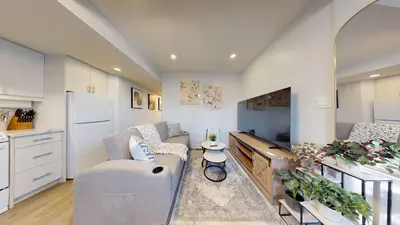 a living room with a couch and a tv at New Bright 1BR Basement Suite in York in Toronto