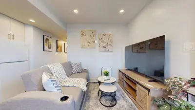 a living room with a couch and a flat screen tv at New Bright 1BR Basement Suite in York in Toronto