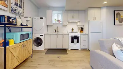 a kitchen with white appliances and a couch at New Bright 1BR Basement Suite in York in Toronto