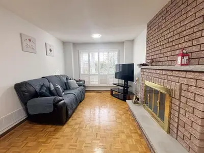 a living room with a couch and a brick fireplace at Relocation Ready- Pet-Friendly 4BR-Core of transit in Vaughan