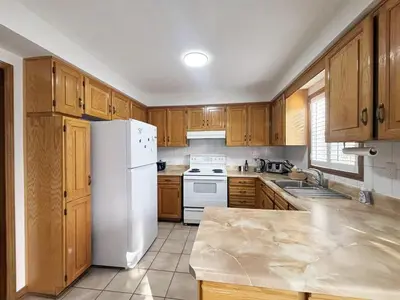 a kitchen with wooden cabinets and a white refrigerator at Relocation Ready- Pet-Friendly 4BR-Core of transit in Vaughan