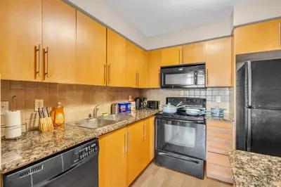 a kitchen with wooden cabinets and stainless steel appliances at 2 bedroom spacious apartment in Mississauga in Mississauga